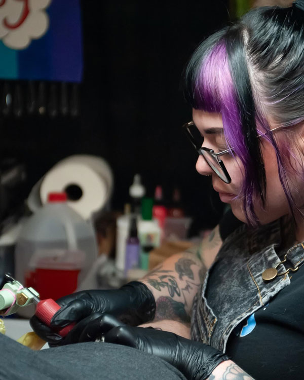 Female tattoo artist working on a tattoo